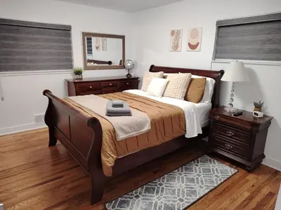 a bedroom with a large bed and a mirror at Home with Garden 3BR Perfect Family & Groups in Denver