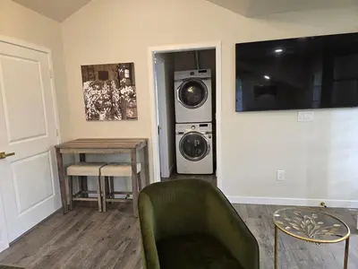a living room with a washing machine and a green chair at Luxury Living in the city in Denver