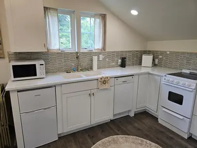 a kitchen with white cabinets and white appliances at Luxury Living in the city in Denver