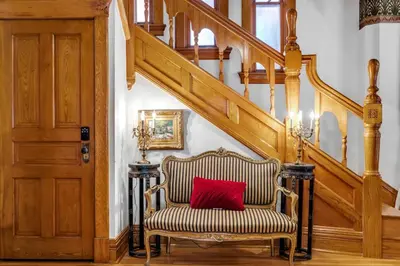 a chair with a red pillow sitting under a staircase at Historic Cap Hill Gem Prime Location Walkable in Denver