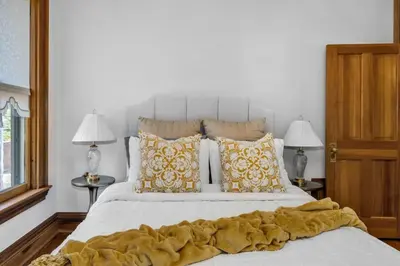 a bedroom with a large white bed with yellow pillows at Historic Cap Hill Gem Prime Location Walkable in Denver