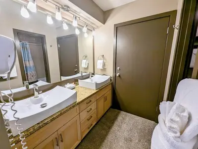 a bathroom with two sinks and a large mirror at Quicksilver 1671 by SummitCove Lodging in Keystone