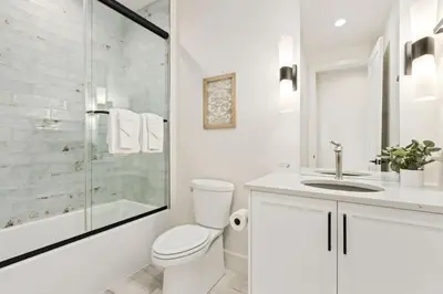 a white bathroom with a toilet and a shower at Bridle Ridge Retreat - Modern Comfort, Open Views in Timnath