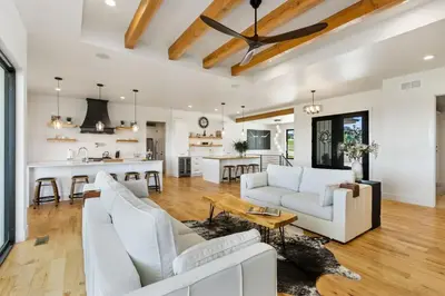 a living room with white furniture and a kitchen at Bridle Ridge Retreat - Modern Comfort, Open Views in Timnath