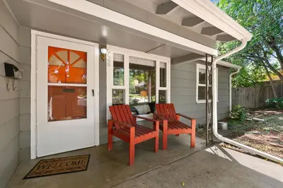 a porch with two chairs and a table and a door at Urban Nest - Garage, Sunroom & Fenced Yard in Fort Collins