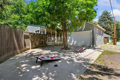 a patio with a table and a tree in a yard at Urban Nest - Garage, Sunroom & Fenced Yard in Fort Collins