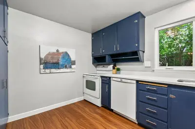 a kitchen with blue cabinets and a window at Urban Nest - Garage, Sunroom & Fenced Yard in Fort Collins