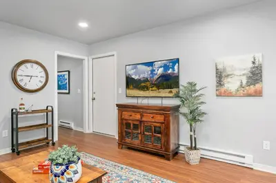 a living room with a clock on the wall at Urban Nest - Garage, Sunroom & Fenced Yard in Fort Collins