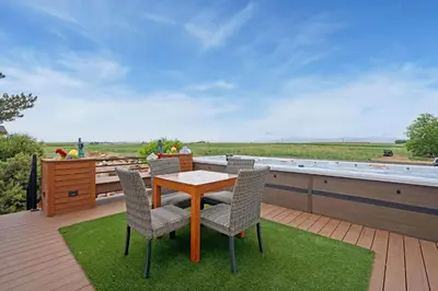 a patio with a table and chairs on a deck at Wright House - Country Retreat with Spa, EV & Garage in Loveland