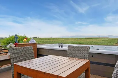 a deck with a table and chairs and a tub at Wright House - Country Retreat with Spa, EV & Garage in Loveland