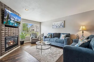 a living room with two blue couches and a fireplace at Parkside Retreat - 2 Suites, Office, Garage in Fort Collins