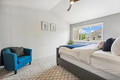 a bedroom with a bed and a blue chair at Parkside Retreat - 2 Suites, Office, Garage in Fort Collins