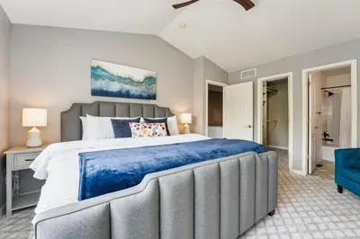 a bedroom with a large bed and a blue chair at Parkside Retreat - 2 Suites, Office, Garage in Fort Collins