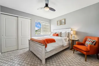a bedroom with a bed and an orange chair at Parkside Retreat - 2 Suites, Office, Garage in Fort Collins