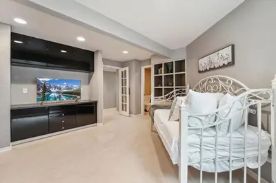 a bedroom with a white bed and a tv at Parkside Retreat - 2 Suites, Office, Garage in Fort Collins