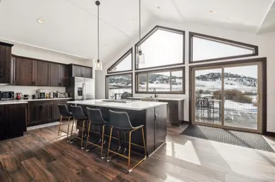 a kitchen with a large window and a kitchen island with chairs at 4br Mountain View Home - 5 Minutes To Granby Ranch in Granby