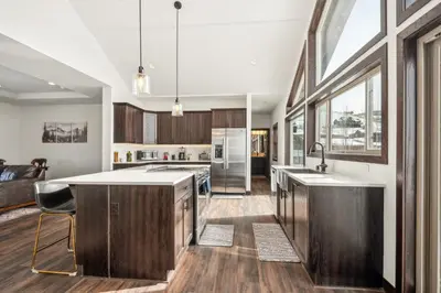a kitchen with wooden cabinets and a large window at 4br Mountain View Home - 5 Minutes To Granby Ranch in Granby