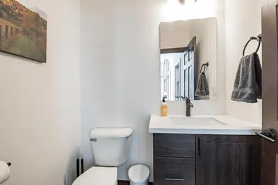 a bathroom with a toilet and a sink and a mirror at 4br Mountain View Home - 5 Minutes To Granby Ranch in Granby