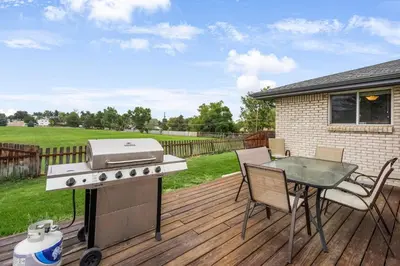 a grill on a deck with a table and chairs at Arvada Retreat + 6 BD + Movie Theater in Arvada