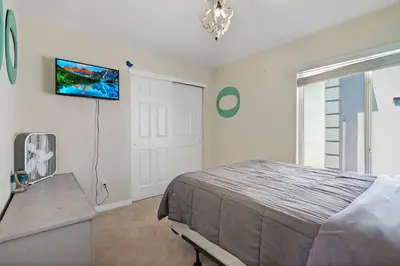 a bedroom with a bed and a tv on the wall at HUGE Downtown Getaway! w/Hot Tub in Arvada