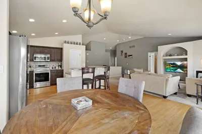 a kitchen and living room with a wooden table and chairs at HUGE Downtown Getaway! w/Hot Tub in Arvada