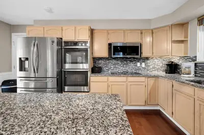 a kitchen with wooden cabinets and stainless steel appliances at Huge Arvada Retreat! Quiet Area in Arvada