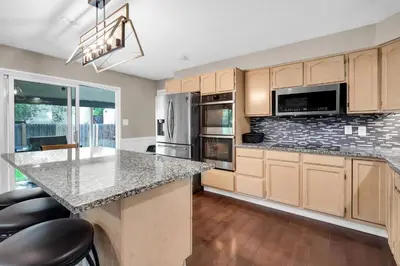 a kitchen with wooden cabinets and a granite counter top at Huge Arvada Retreat! Quiet Area in Arvada