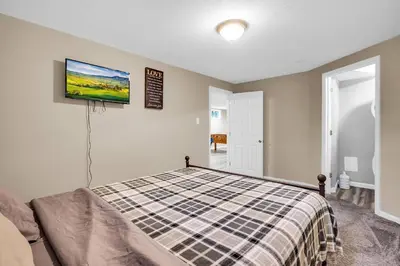 a bedroom with a bed and a tv on the wall at Huge Arvada Retreat! Quiet Area in Arvada