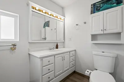 a white bathroom with a sink and a toilet at Heated Pool BBQ Cabana Gardens in Denver