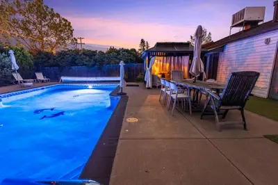 a swimming pool with a table and chairs next to a house at Heated Pool BBQ Cabana Gardens in Denver