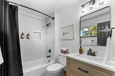 a bathroom with a tub and a sink and a toilet at Theater, Hot Tub, Mini Golf, Luxe Fun House in Centennial