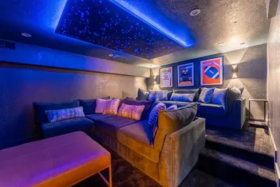 a living room with a couch and blue lights at Theater, Hot Tub, Mini Golf, Luxe Fun House in Centennial
