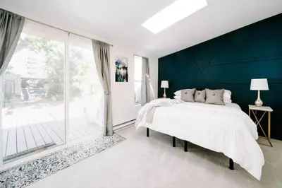 a bedroom with a large bed and a large window at Olde Town Ambler A Distinctive Walkable Retreat in Arvada