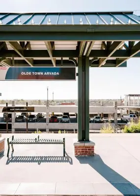 a bench at a train station with a bridge at Olde Town Ambler A Distinctive Walkable Retreat in Arvada
