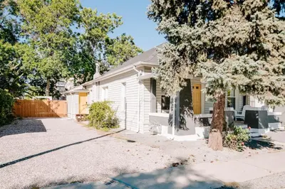 a white house with a tree in front of it at Olde Town Ambler A Distinctive Walkable Retreat in Arvada