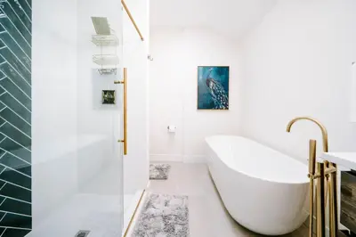 a white bathroom with a tub and a shower at Olde Town Ambler A Distinctive Walkable Retreat in Arvada