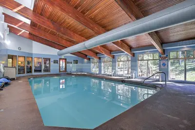 a large swimming pool in a building with wooden ceilings at 2 Mi to Winter Park Resort Mtn-View Haven! in Winter Park