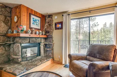 a living room with a stone fireplace and a couch at 2 Mi to Winter Park Resort Mtn-View Haven! in Winter Park