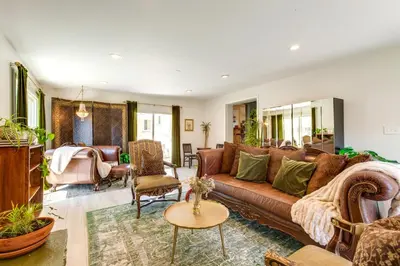 a living room with a brown couch and chairs at Near Shops and Eats Elegant Home in Wheat Ridge! in Wheat Ridge