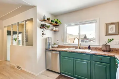 a kitchen with green cabinets and a window at Near Shops and Eats Elegant Home in Wheat Ridge! in Wheat Ridge
