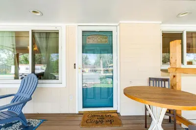 a blue door on a house with a table and chairs at Near Shops and Eats Elegant Home in Wheat Ridge! in Wheat Ridge