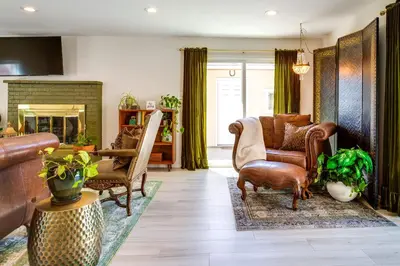 a living room with a couch and chairs and a fireplace at Near Shops and Eats Elegant Home in Wheat Ridge! in Wheat Ridge