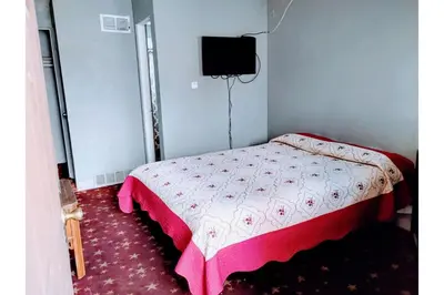 a small bedroom with a bed with a pink comforter at Hotel O Englewood-South Denver CO in Englewood