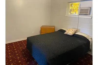 a bedroom with a black bed and a window at Hotel O Englewood-South Denver CO in Englewood