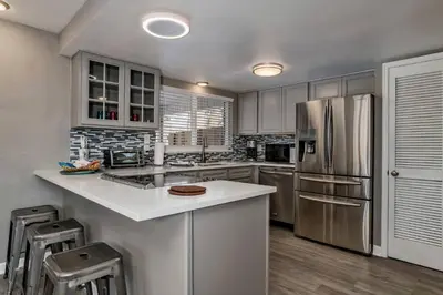 a kitchen with a stainless steel refrigerator and cabinets at West Denver Home 8 Beds! Game Room in Lakewood