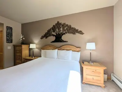 a bedroom with a bed with a tree on the wall at Hidden River Lodge 5965 by SummitCove Lodging in Keystone