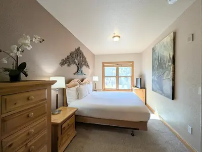 a bedroom with a large bed and a window at Hidden River Lodge 5965 by SummitCove Lodging in Keystone