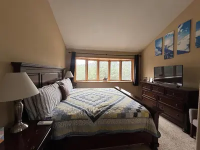 a bedroom with a bed and a dresser and a window at Your Mountain Retreat in Loveland
