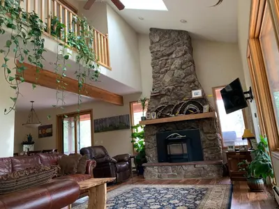a living room with a couch and a stone fireplace at Your Mountain Retreat in Loveland