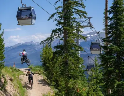 a couple of people riding a bike down a dirt road at 130 Discovery Court at Rendezvous home in Fraser